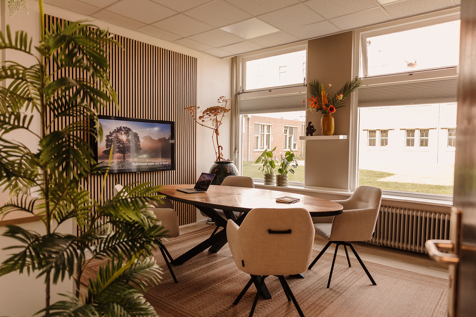 Warme werkkamer met ovalen tafel en daglicht